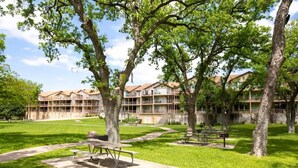 A courtyard with picnic tables and a building with multiple balconies.