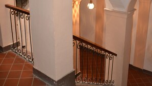 Un escalier avec des murs blancs et un revêtement de sol en carreaux rouges.