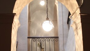 Un escalier doté d’une balustrade et un balcon avec une rambarde en fer forgé.