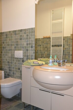 Ein Badezimmer mit Toilette, Waschbecken und Spiegel.