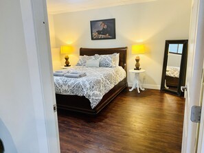 Cozy retreat with a large bed, bedside lamps, and a framed picture above.
