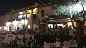 An outdoor dining area with tables and chairs, a sign for TPH PUB 2.0 Steakhouse, and a tree in the foreground. - Total tranquility in the hills of Budoni (San Lorenzo)