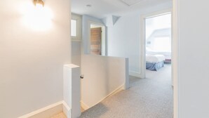 Un couloir avec une porte donnant sur une chambre.