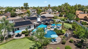 Zona residencial con piscina, paneles solares en los tejados y césped bien cuidado.
