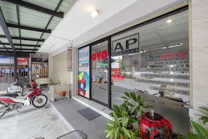Fachada de tienda con un amplio escaparate que muestra diversos letreros y anuncios.