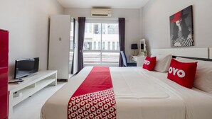 A hotel room with a bed, a TV, a desk, and a window with curtains. - OYO 75323 Tha Burapa Home Bangsean (Chonburi)