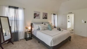 A bedroom with a bed, bedside table, and a ceiling fan.