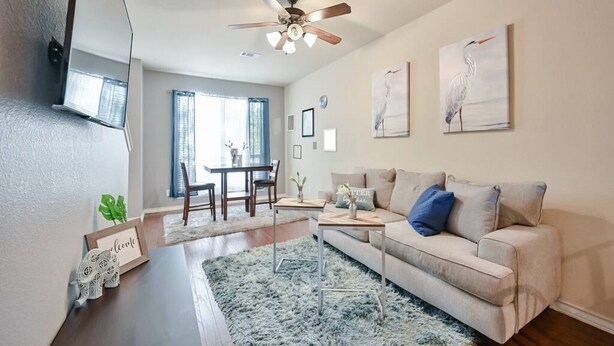 A living room with a sofa, coffee table, and artwork on the wall.