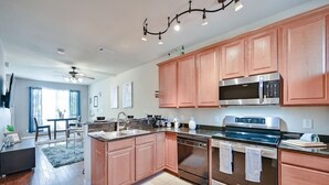 A modern kitchen with wooden cabinets, stainless steel appliances, and a central island.
