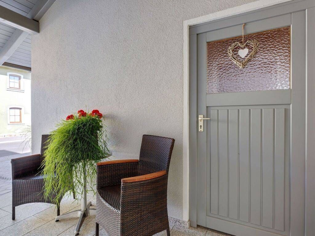 Un porche con sillas de mimbre y una planta en maceta.