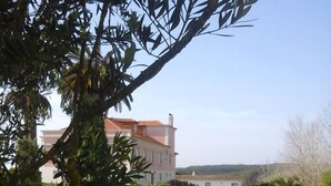 A well-maintained grassy lawn with a building in the background. - Hotel Rural Quinta do Juncal (Peniche)