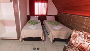 A small, cozy room with two single beds, a red curtain, and a wooden ceiling. - Espaço Chalé Cereja (Cachoeira Paulista)