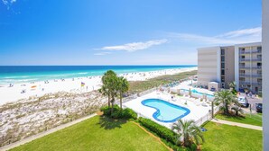 Un hotel con piscina, vistas a la playa y zona de estacionamiento.