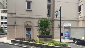 A building with a large entrance, a signboard, and a truck parked nearby. - Ancol Homestay (Jakarta)