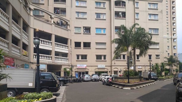A multi-story building with balconies and a parking area. - Ancol Homestay (Jakarta)