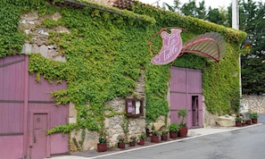 A building with ivy-covered walls, a purple awning, and a sign that reads 'La Table.'