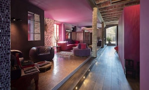 A modern interior with a stone wall, leather sofa, and a wooden floor.