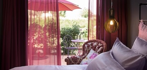 Ein Schlafzimmer mit Bett, einem Sessel, einem Tisch und einer HĂ€ngeleuchte.