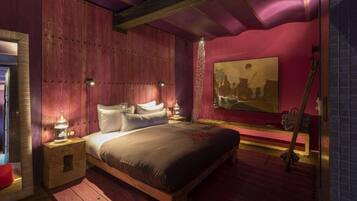 Un dormitorio con una cama de madera, dos mesitas de noche, un cuadro y una guitarra.