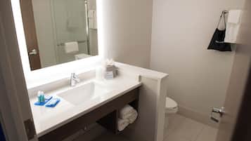 A bathroom with a white sink, a mirror, a towel rack, and a toilet.
