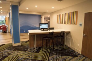 A hotel lobby with a reception desk, a computer monitor, and a seating area with chairs. - Holiday Inn Express & Suites Dayton North - Vandalia by IHG (Dayton)