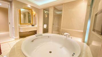 A large oval bathtub in a well-lit bathroom with a mirror and vanity.