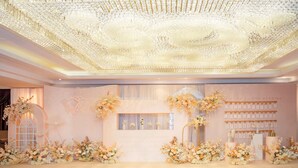 Un espace dédié à la réception de mariage, agrémenté d’un lustre, de compositions florales et d’une pancarte de bienvenue.