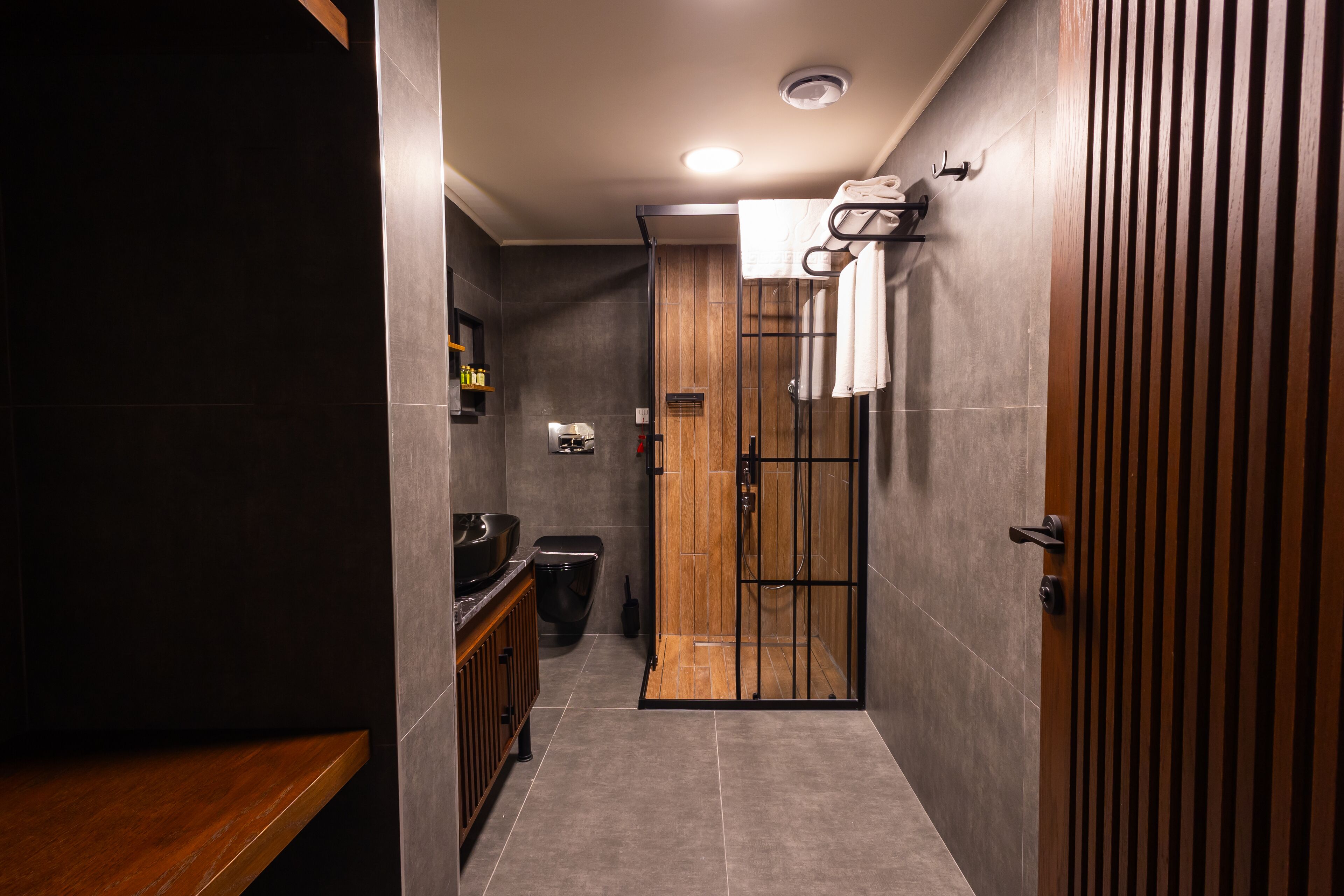 A modern bathroom with a shower, toilet, and vanity.
