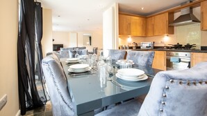 A dining area with a glass table set for six, surrounded by upholstered chairs. - Apartment 9 (Worksop)
