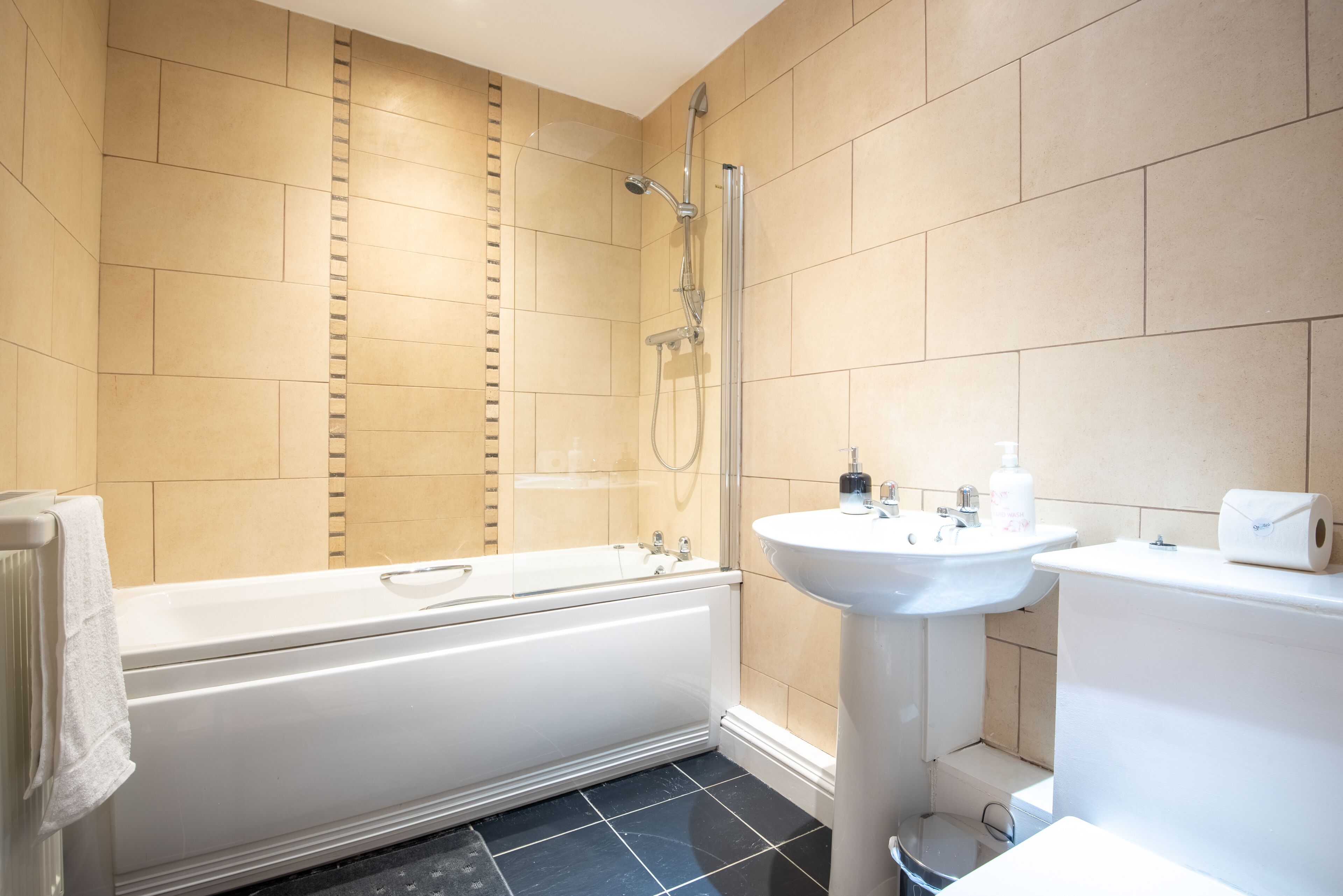 Un baño moderno con bañera, lavamanos e inodoro.