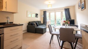 A modern kitchen with a dining area, a sofa, and a TV. - No16 (Mansfield)