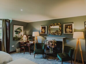 A room with a fireplace, green chairs, a desk with lamps, and framed artwork on the walls. - 2 bedroom accommodation in Portpatrick, near Stranraer (Portpatrick, near Stranraer)