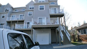 Un immeuble résidentiel à plusieurs étages, doté d’un garage, d’un escalier menant aux étages supérieurs et d’un balcon au deuxième étage.