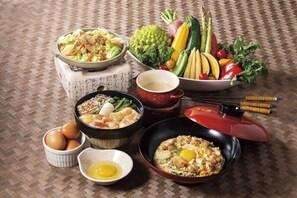 Disposição tradicional de refeição japonesa com diversos pratos, incluindo uma tigela de legumes, um caldeirão de sopa e uma tigela de arroz.