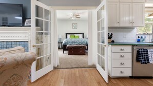Una habitación con cama, televisor, zona de cocina y mesa de comedor.