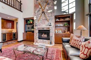 Cozy living area with a stone fireplace, leather sofa, and oven.