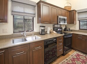 Enjoy cooking in this well-equipped kitchen with a double sink, coffee maker, and stainless steel appliances.