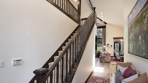 A spacious living area with a staircase, a large painting, and a cozy seating area. - Single family remodeled platinum level home with private hot tub!! (Beaver Creek)