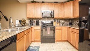 A kitchen with wooden cabinets, a stainless steel refrigerator, a microwave, and a stove. - Beautiful Upgraded Luxury Condo in Great Location with Mtn Views & Great Beds (Pigeon Forge)