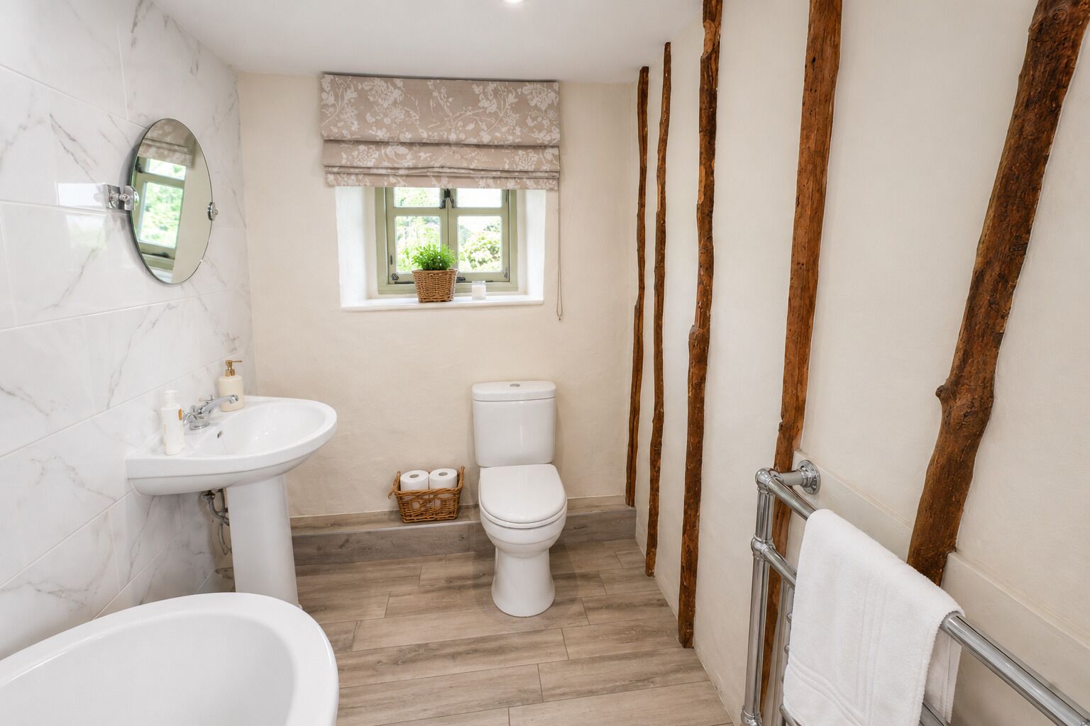 Et badeværelse med hvid vask, toilet og badekar.