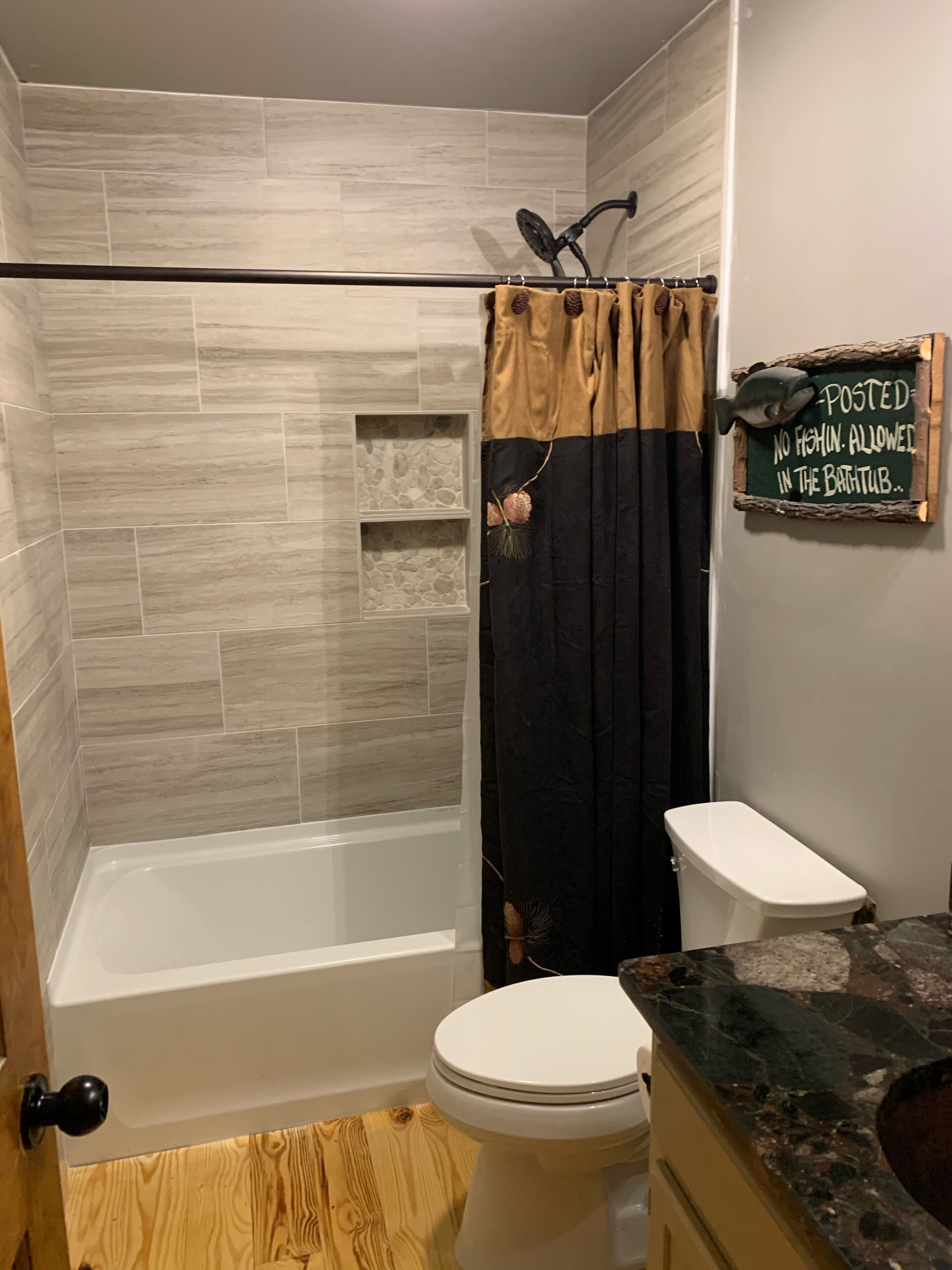 Un baño con ducha, inodoro y tocador.