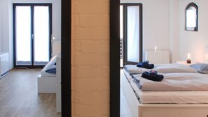 A modern hotel room with a large bed, a bedside table, a wardrobe, and a window with a view. - Fiorita by Interhome (Brusino Arsizio)