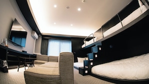 A modern hotel room with a bunk bed, a sofa, a desk, and a flat-screen TV. - GOLDSTAY SAKAE (Nagoya)
