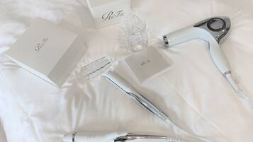 A neatly arranged set of personal care items on a white bedspread.