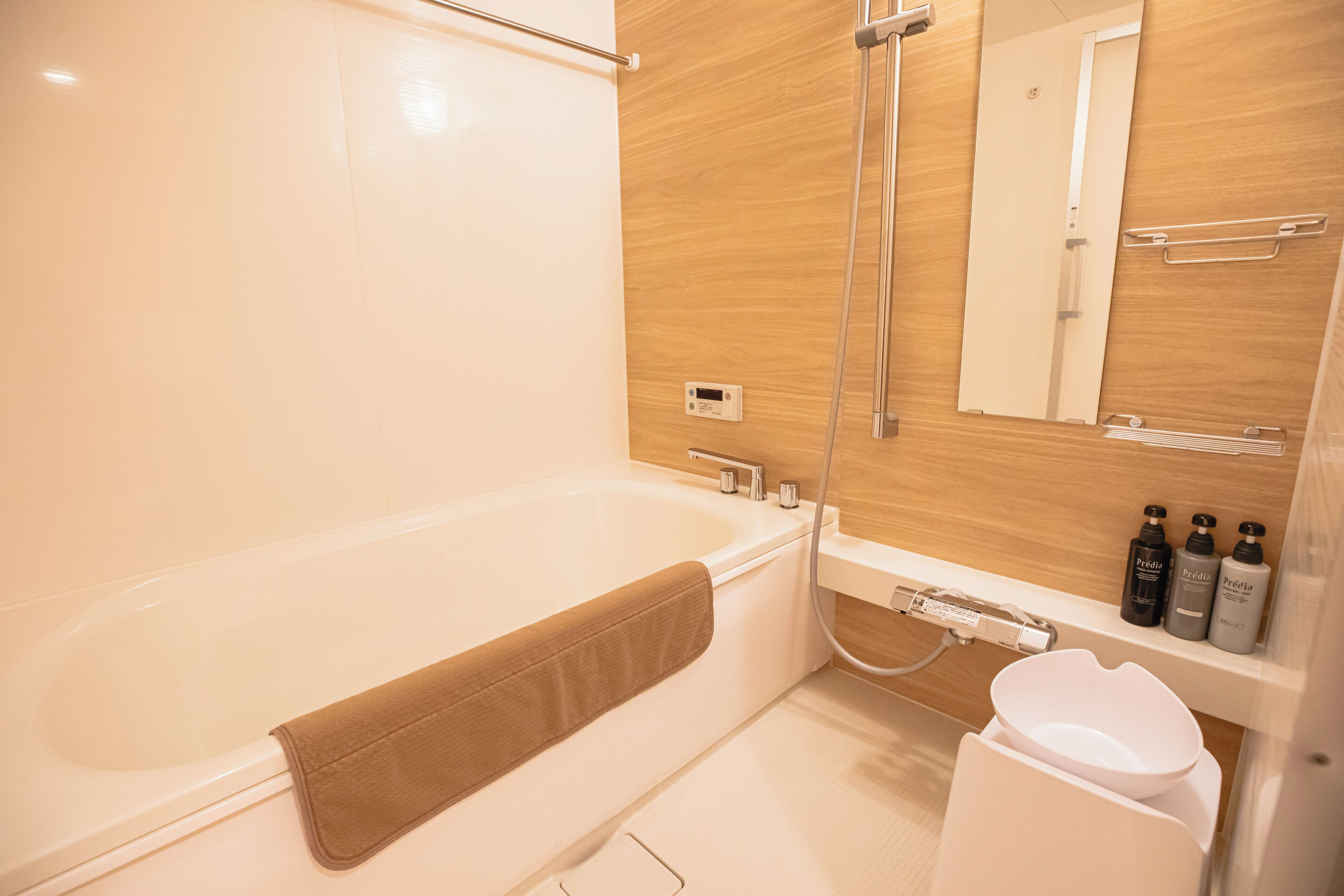 A modern bathroom with a bathtub, a shower, a toilet, and a vanity with toiletries.