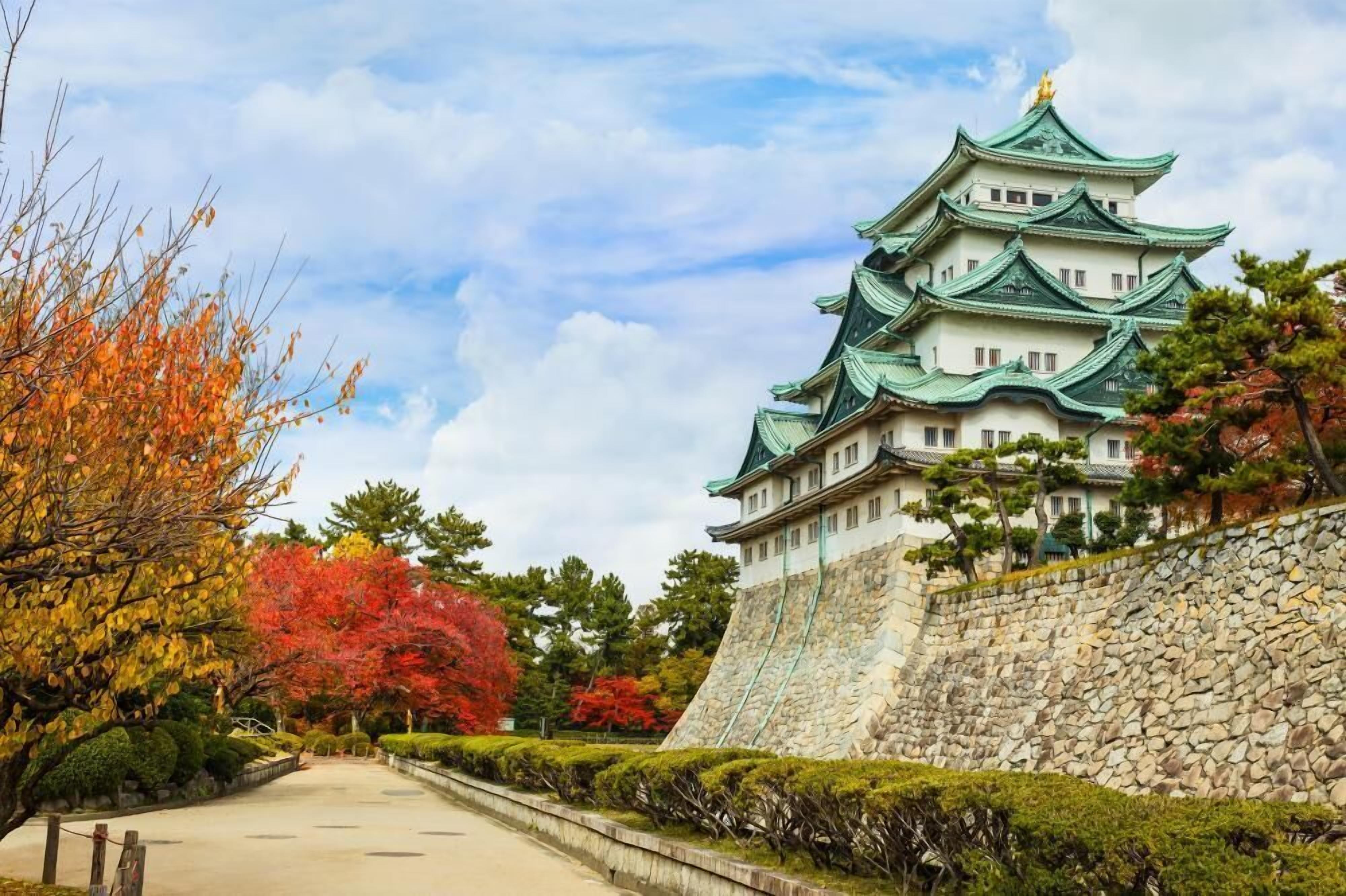A traditional Japanese castle with multiple tiers and a stone wall.