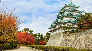 A traditional Japanese castle with multiple tiers and a stone wall.
