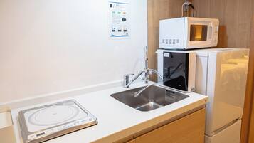 A kitchenette with a microwave, a toaster, and a sink.