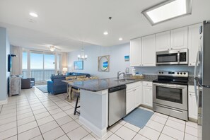 Een moderne keuken met witte kasten, roestvrijstalen apparatuur en een centraal eiland.