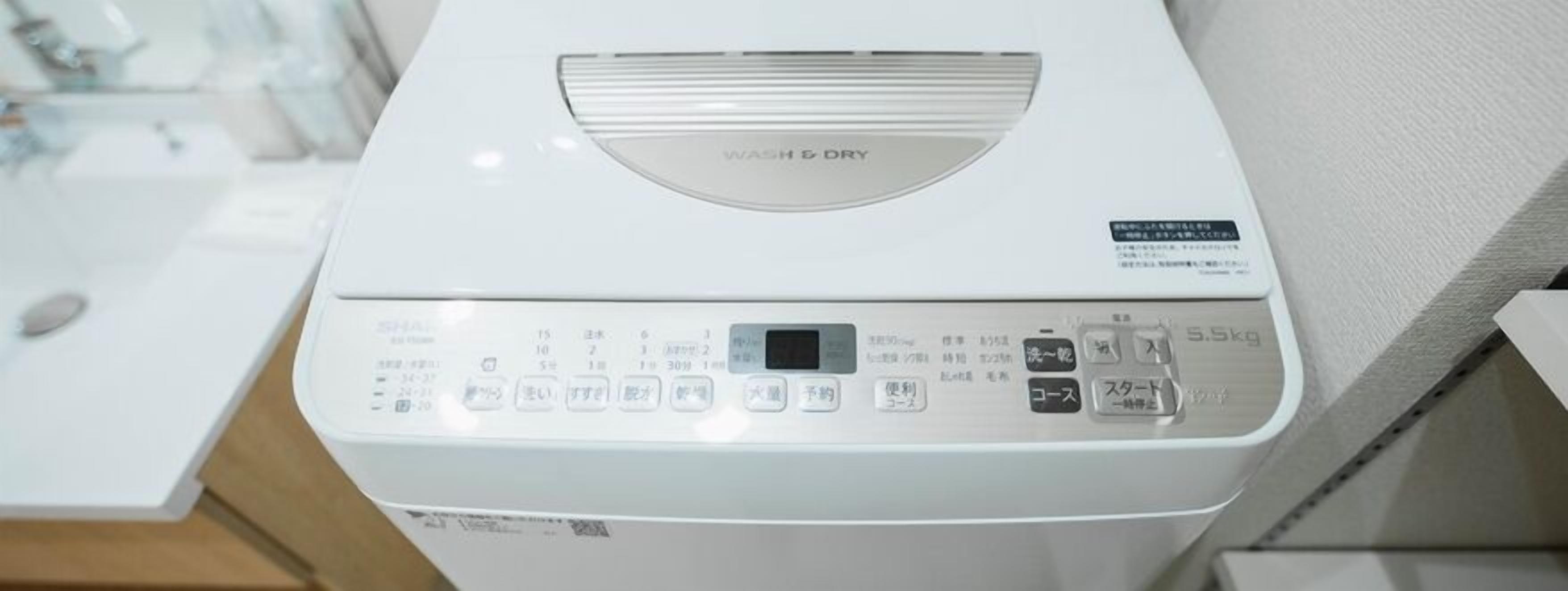 Une machine à laver blanche dotée d’un panneau de commande avec de nombreux boutons et d’un écran numérique.